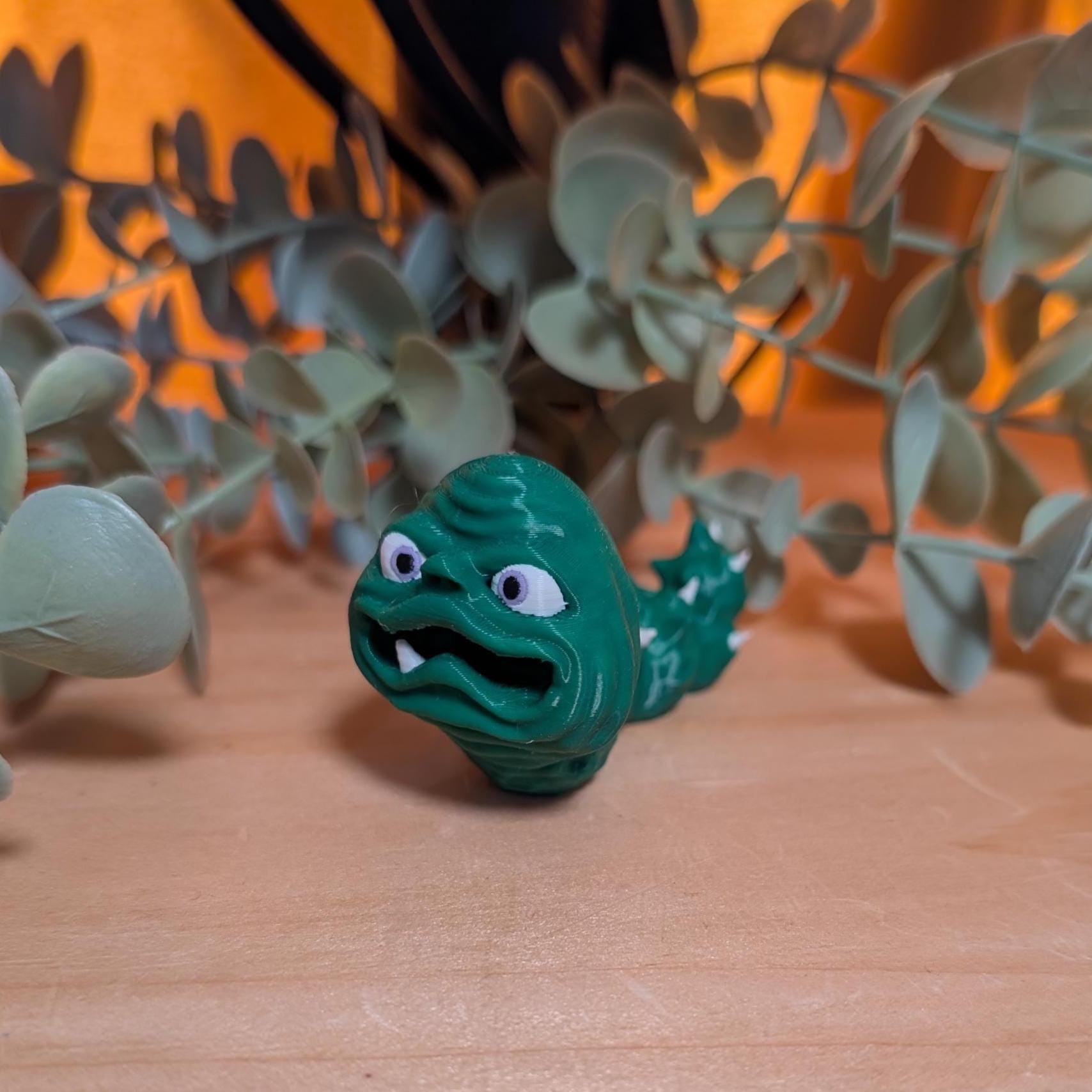 gary the frantic forest grub goblincore creature figurine pocket full of loonies desk collectible.  Green grub with white spikes and one lonely tooth. 