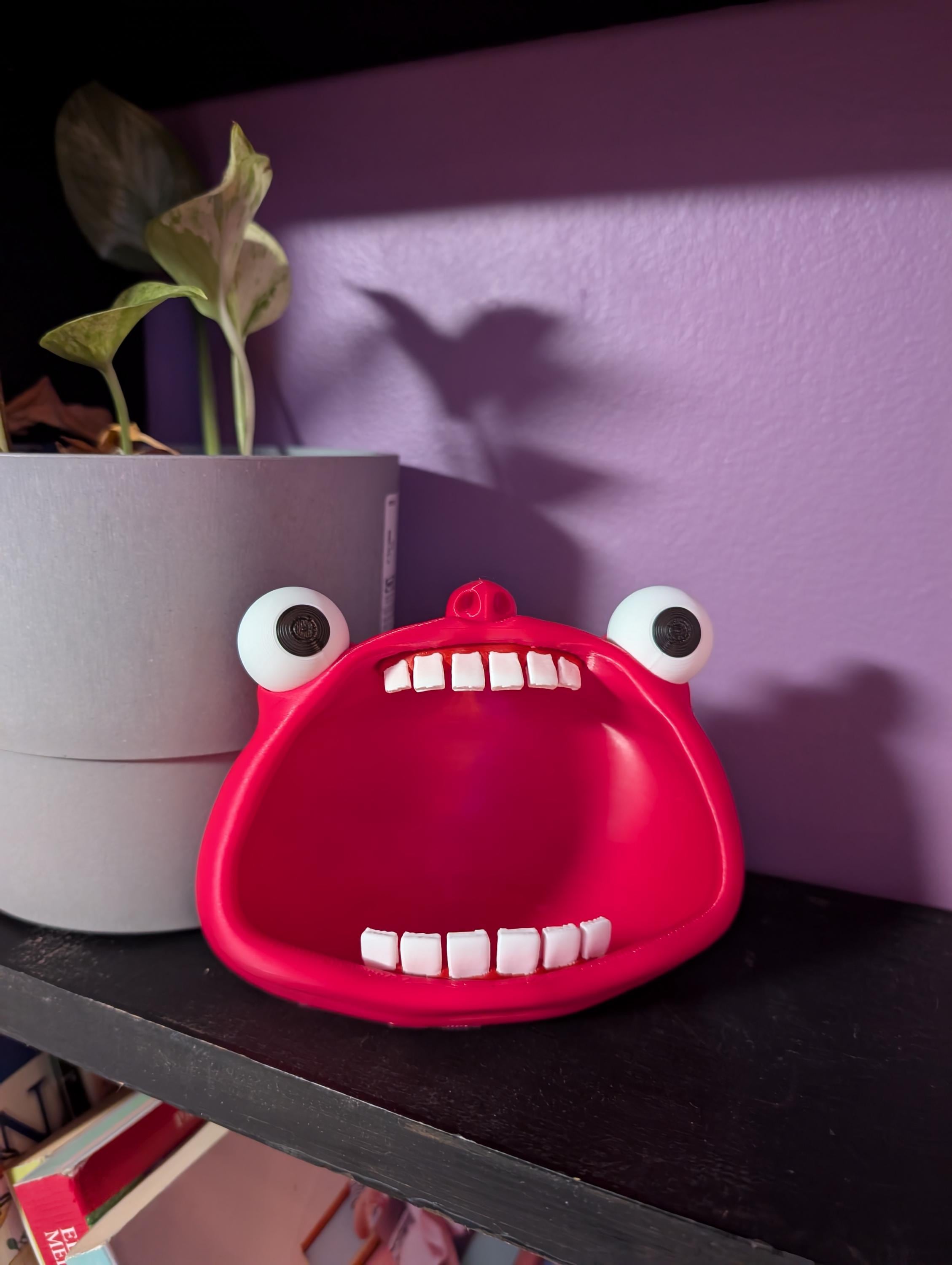 Wide-mouthed monster bowl, with gummy teeth, and wide eyes.  Ideal as a trinket holder.